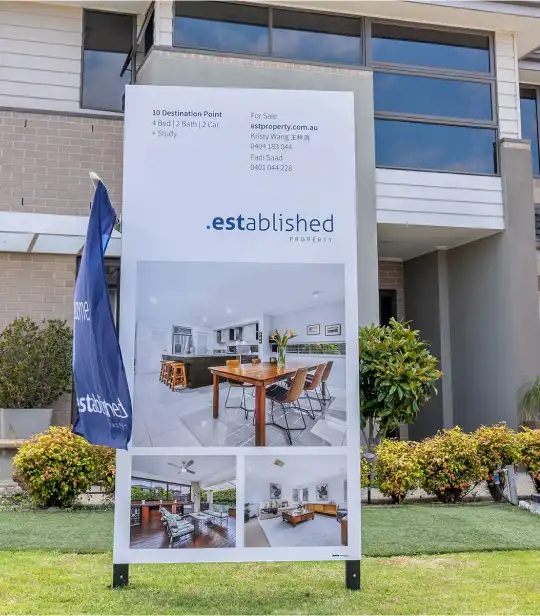 EST Property for‑sale signboard in front of home, promoting property services.
